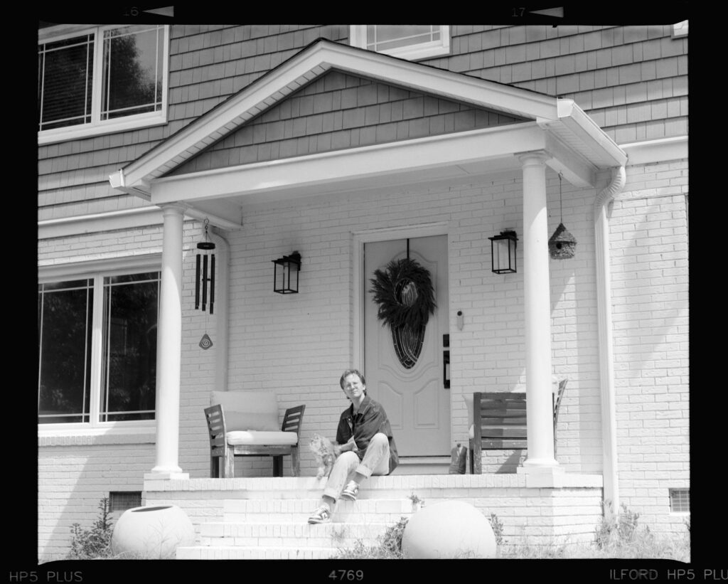 A person sitting on the front steps of a home
