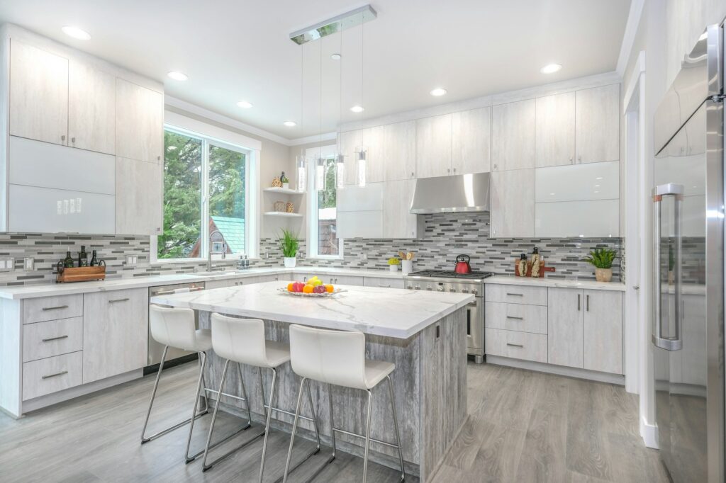 A white kitchen with gray cabinets and a breakfast bar