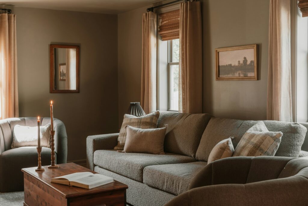 A living room with a sofa, armchair and warm lamps