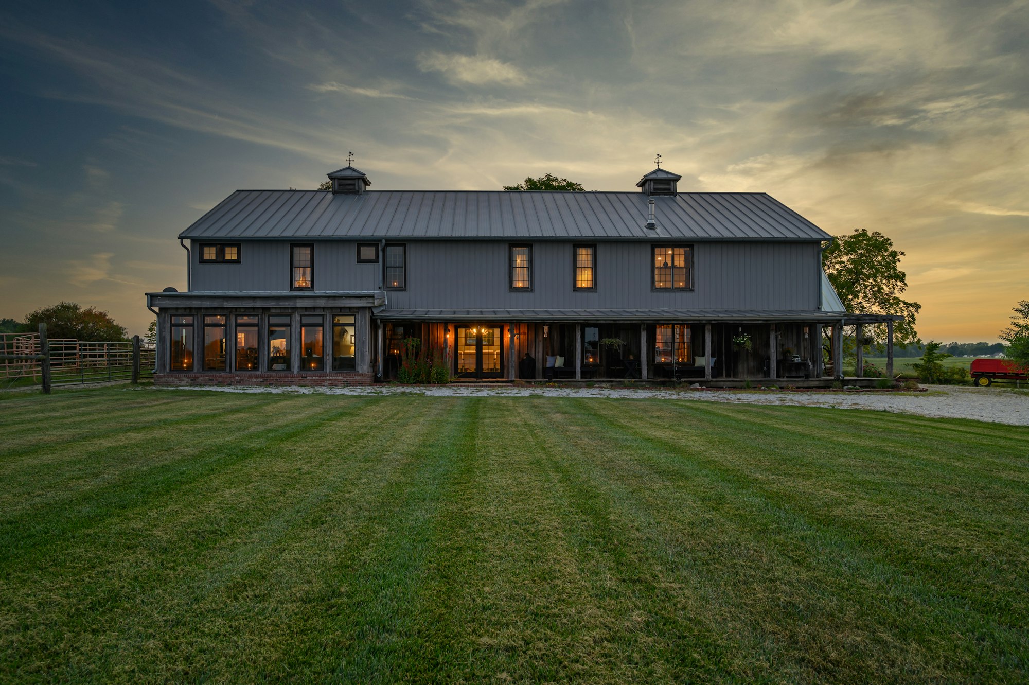 A long home with warm lights on at dusk